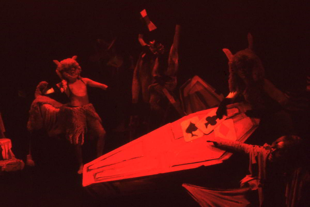 Handspan Theatre Four Little Girls Demons and satyrs play a card game on a coffin