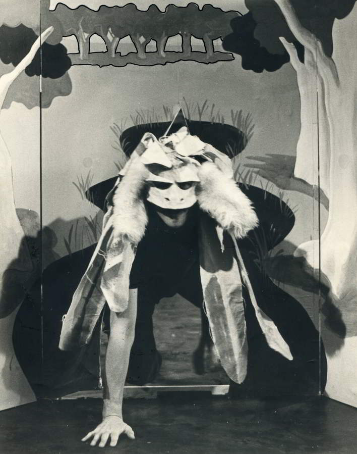 The Bunyip of Berkeley's Creek Handspan Theatre actor in feathered and furred bunyip mask and costume emerging from painted backdrop waterhole