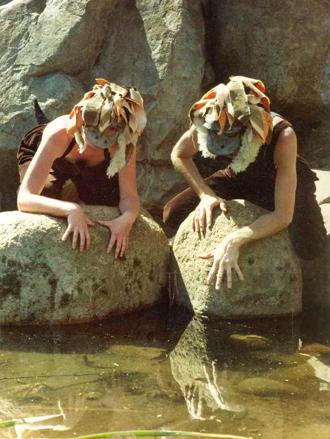 The Bunyip of Berkeley's Creek Handspan Theatre actors in bunyip masks and costumes on a rock looking at their reflections in water