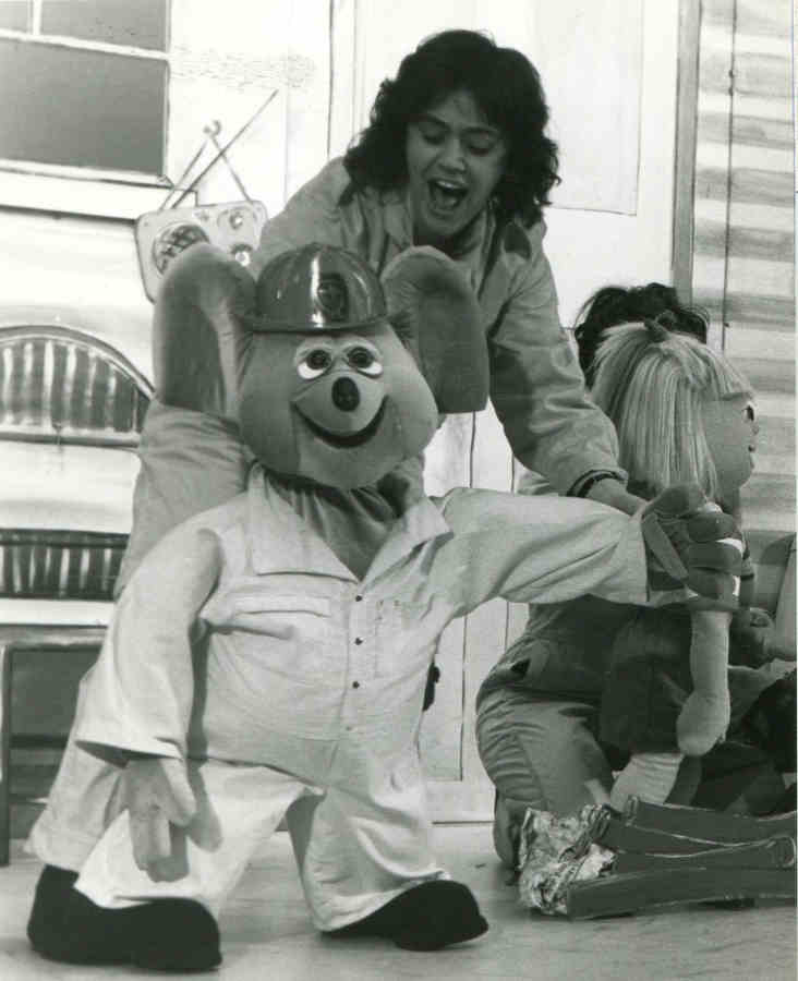 Handspan Theatre Captain Koala woman singing with large koala puppet in fire-fighter costume