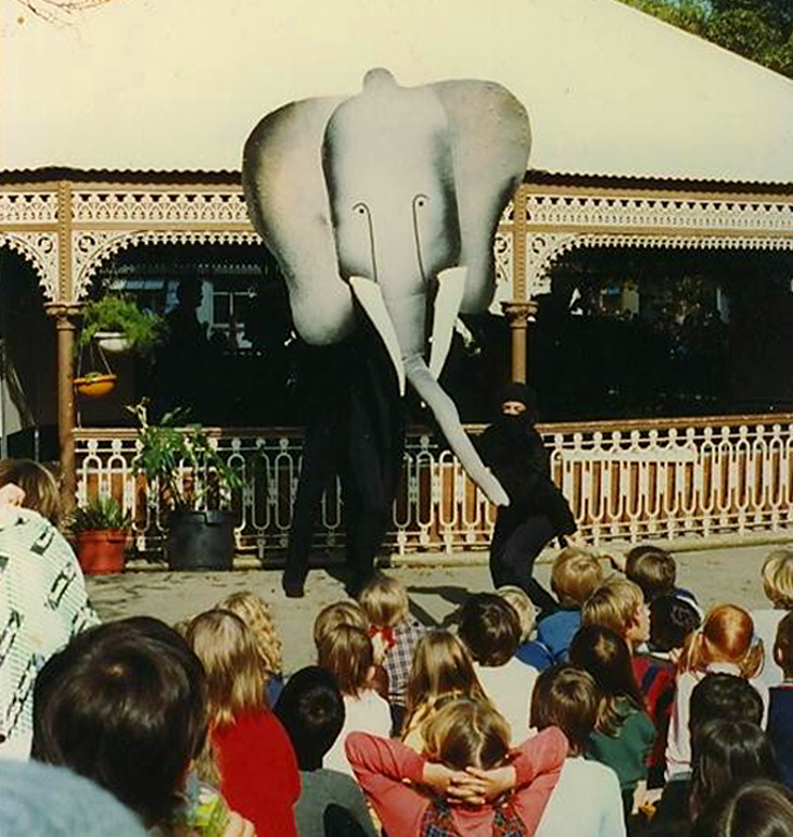 A concert performance at the Rotunda Adelaide Zoo, elephant head puppet and children watching