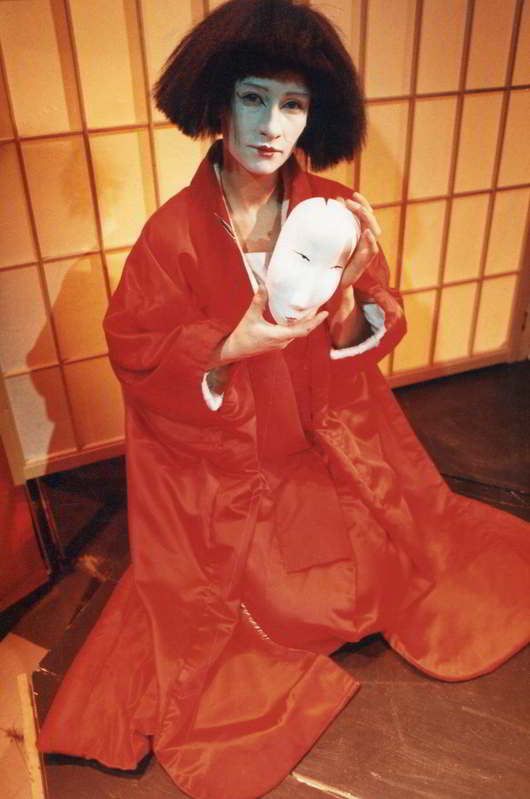 female actor in red kimono with white mask