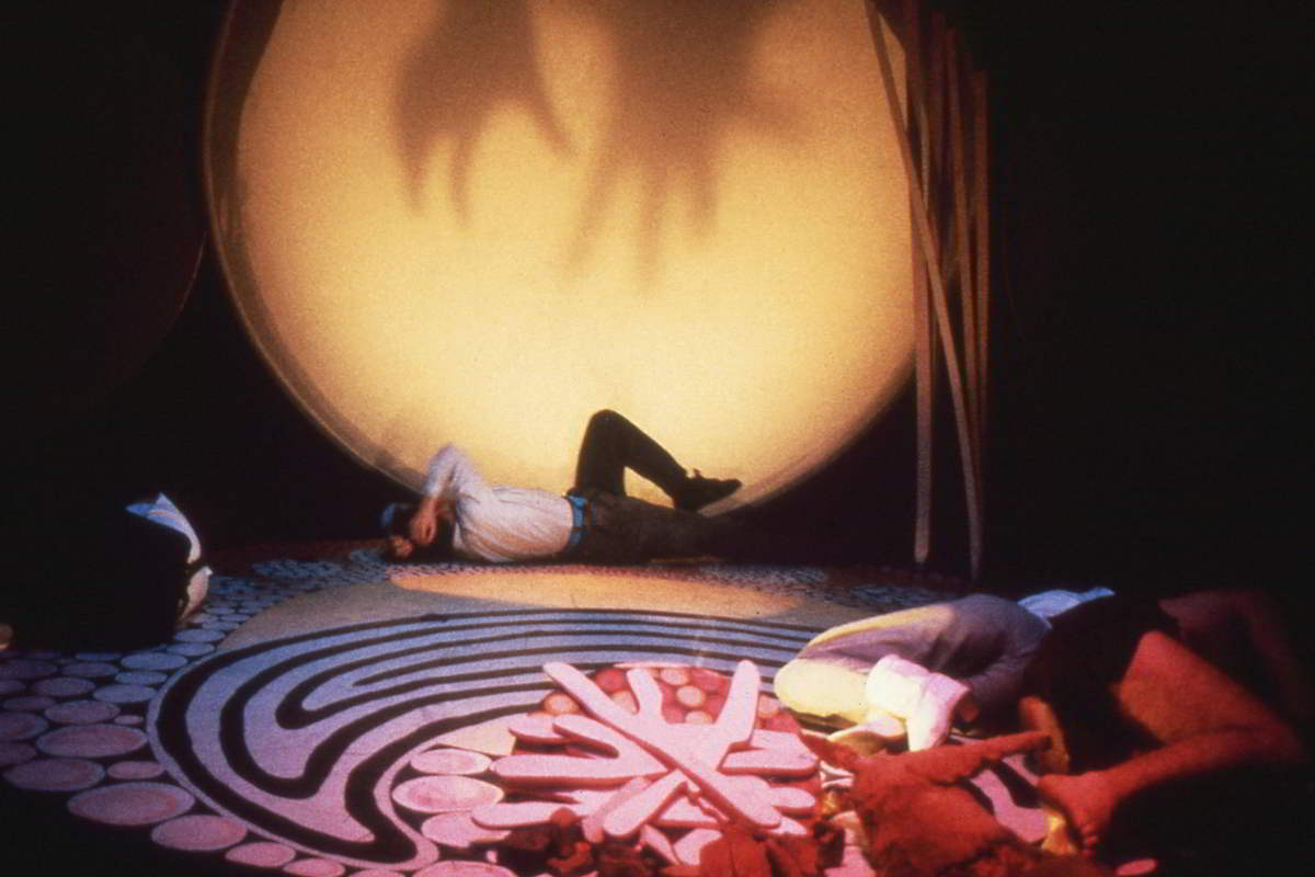 Handspan Theatre The Haunted scrim circle with stars and woman rolling on dot painted floor cloth crying