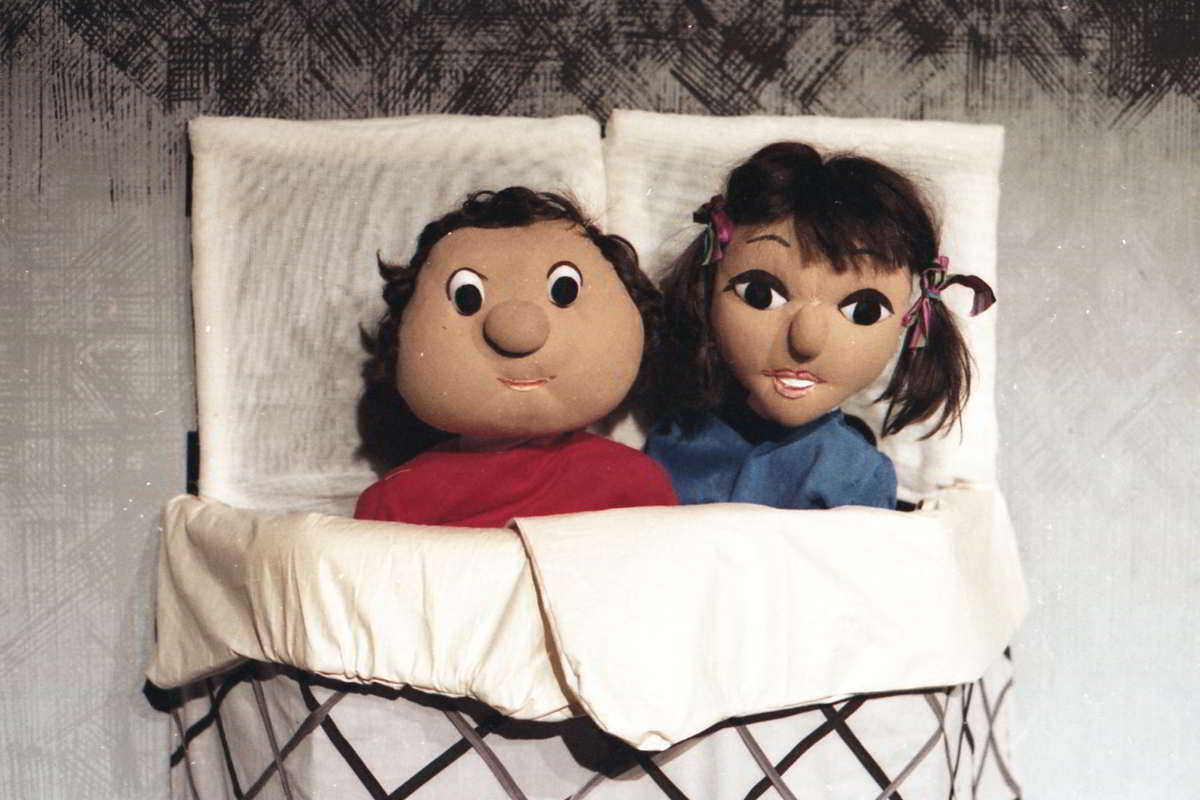 Colour picture of boy and girl puppet in bed