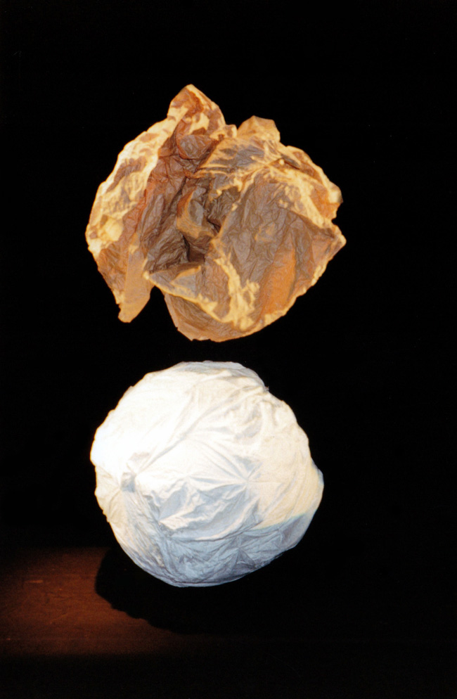Metafour, Katy Bowman Cycle segment - a scrunched ball of brown paper hovering over white cloth ball against black background