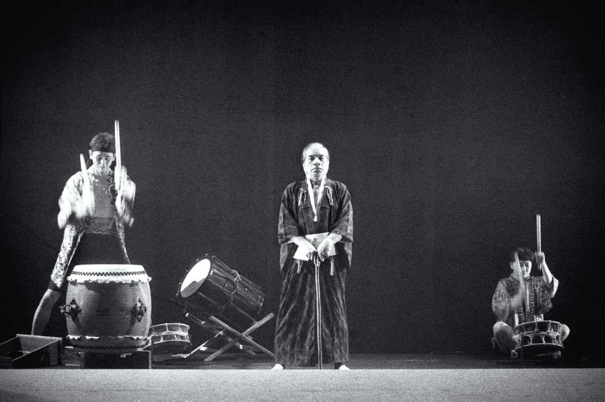 Miss Tanaka Handspan/Playbox One man stands centre-stage with taiko drummers to left and right of him