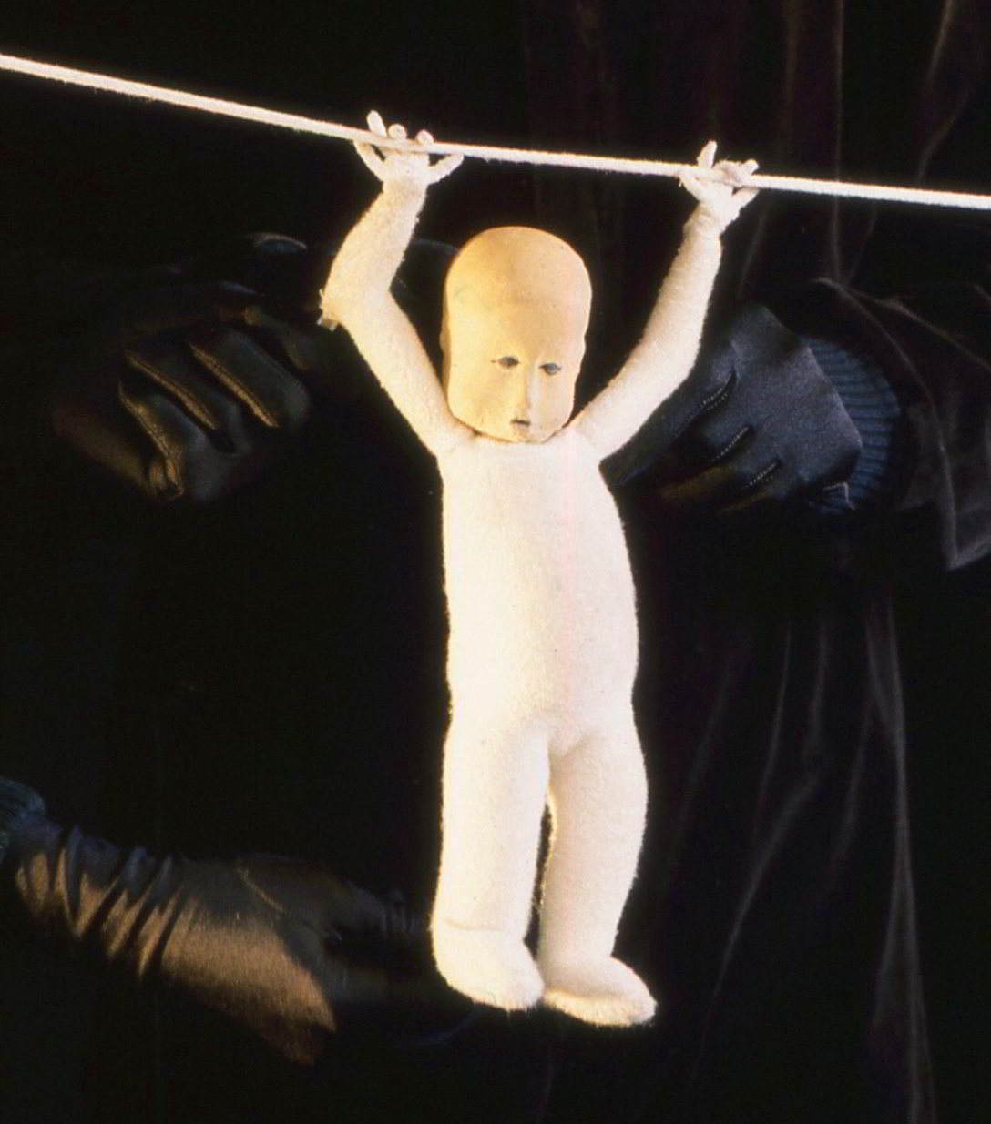 Handspan Theatre Moments a puppet figure hanging by arms swinging on a wire