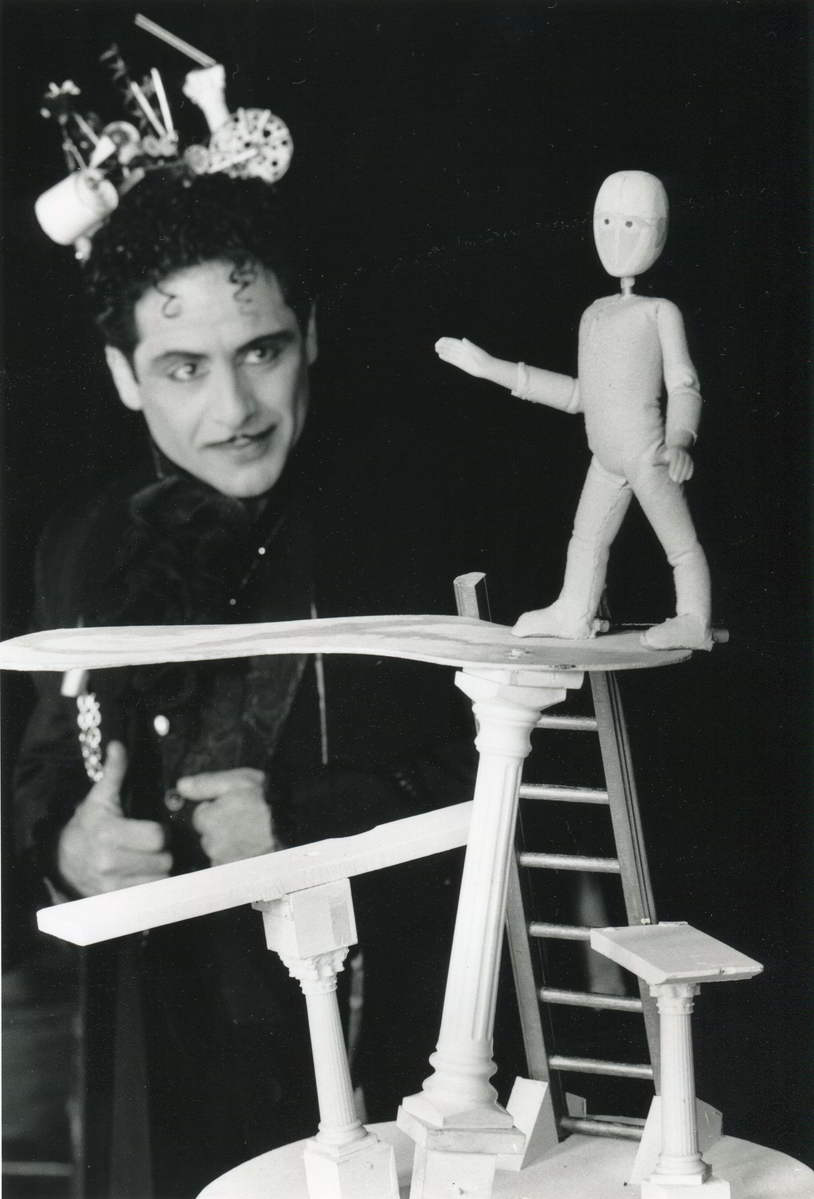 No Right Angles in Paradise Magician Sam Angelico watching a puppet balance on miniature diving board