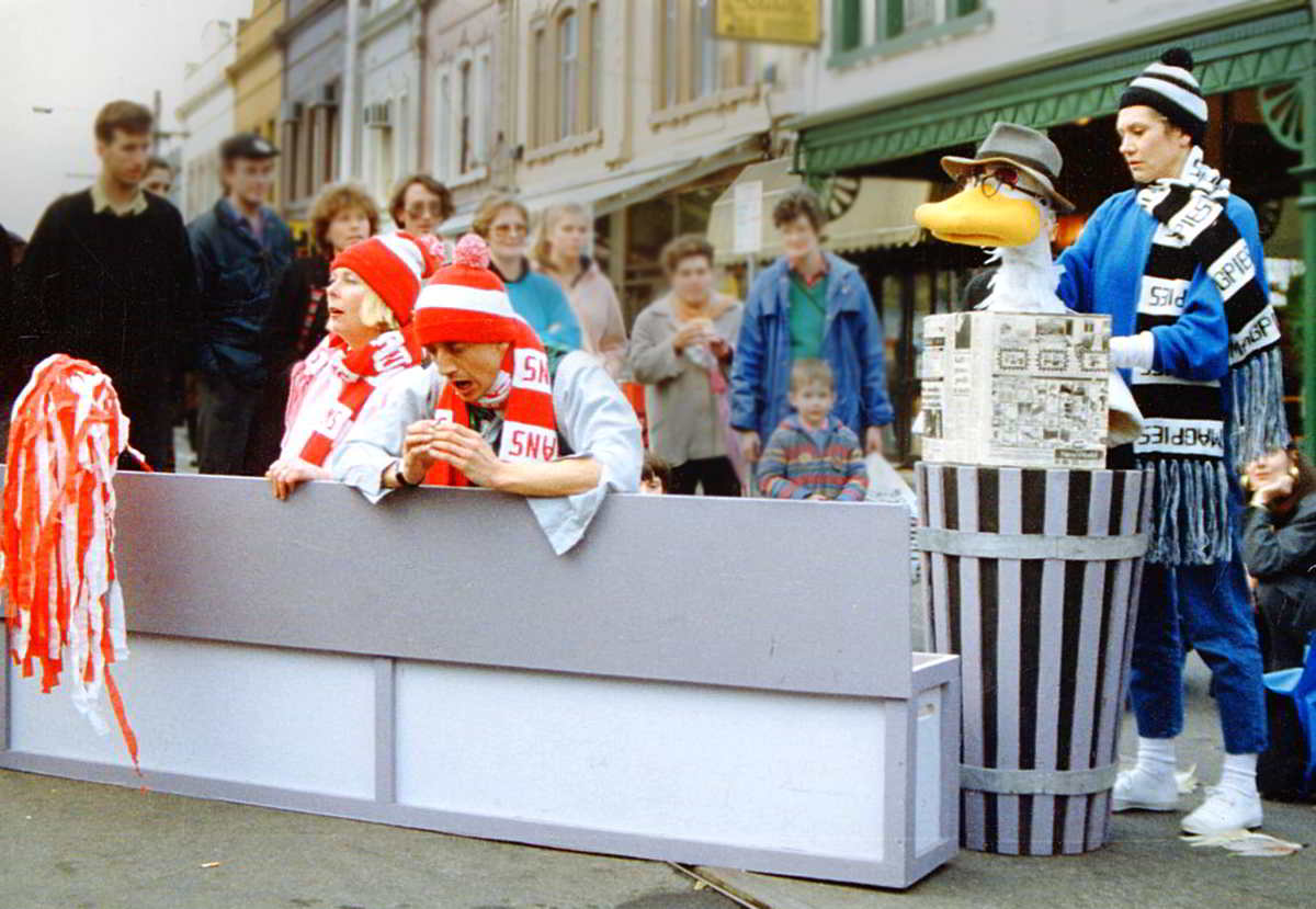 Handspan Theatre Out for A Duck - street performance duck puppet with puppeteer/actors wearing football scarves