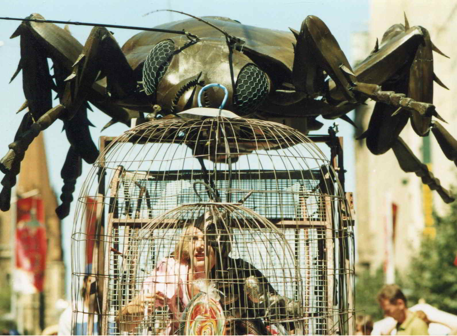 Road Roach parade image large cockroach head on top of cage with woman inside