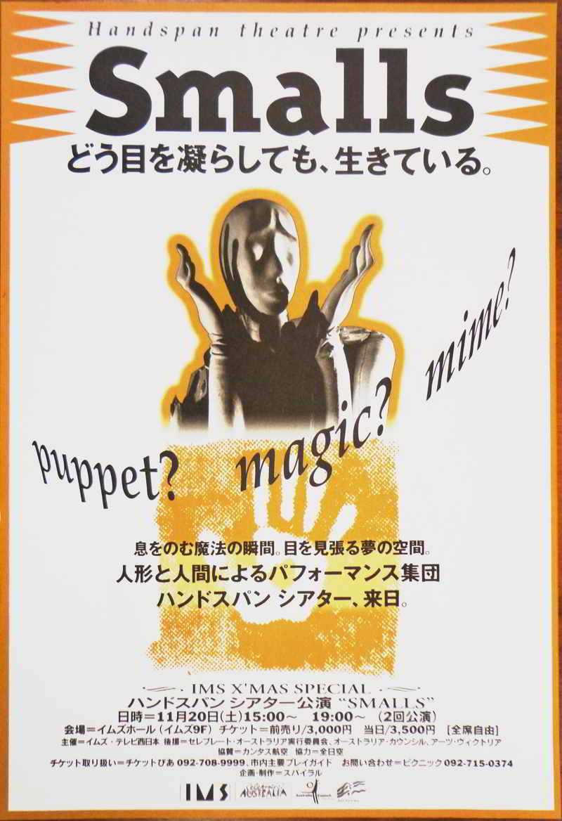 gold black & white poster with text in English & Japanese with central image of puppet head and hands