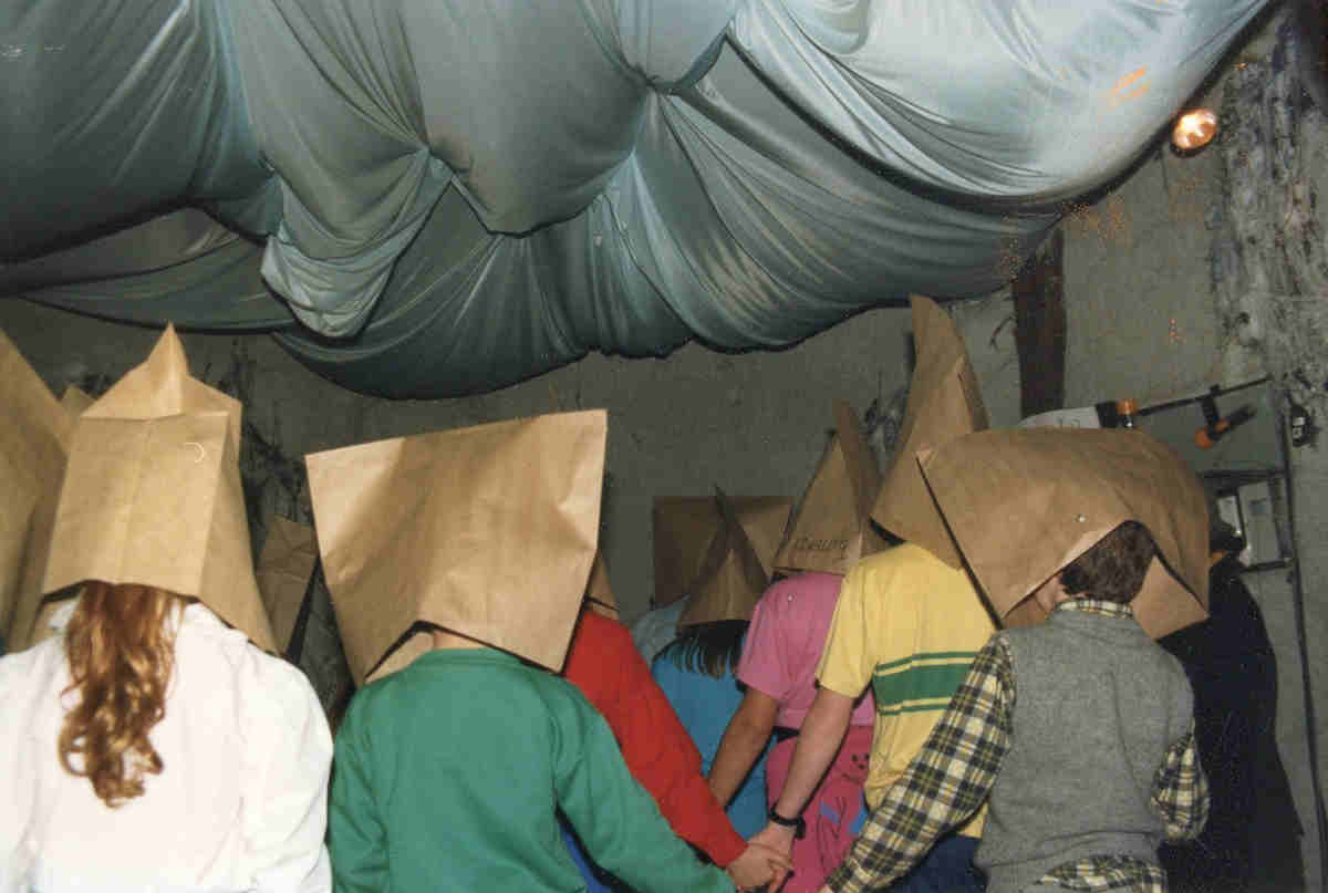 Handspan Theatre Tomorrowland Game participants hooded in paper-bags from behind in a tunnel