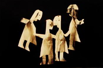 Four life-size paper dolls against a black background. 