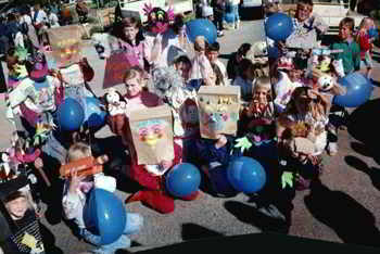 group of around 20 children with their puppet dogs and paperbag masks