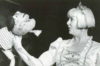 woman wearing tiara with frog puppet wearing beret