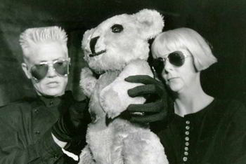 two woman manipulating large teddy-bear