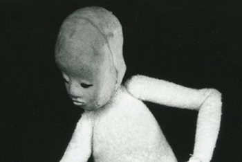 man in spotlight manipulating several crossed bamboo sticks