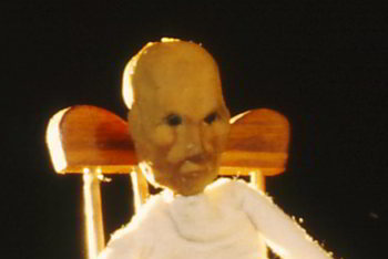 closeup puppet head with its hands over face