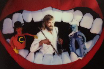cheery dentist and two puppets in large soft-sculpture smiling mouth