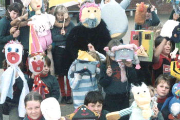 group of around a dozen children with puppets