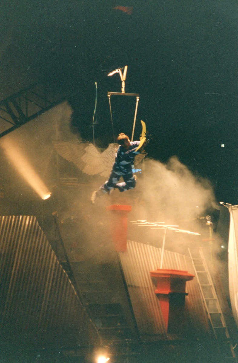 I Dreamt I Could Fly, Handspan Theatre person poised mid-air over stage set representing house roof