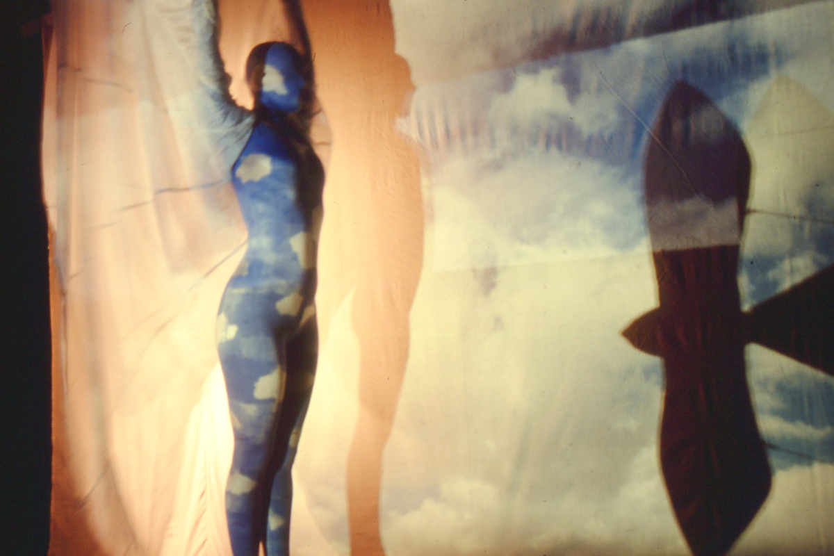 I Dreamt I Could Fly, Handspan Theatre woman in blue body-stocking standing arms upraised with shadow of bird moving past
