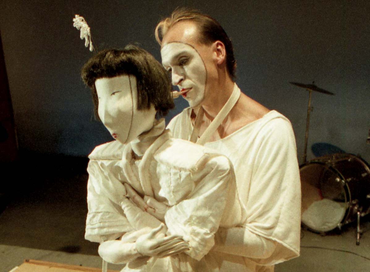 Handspan Theatre Cho Cho San Peter J.Wilson puppeteer in white face makeup operating girl butterfly puppet with mouth control