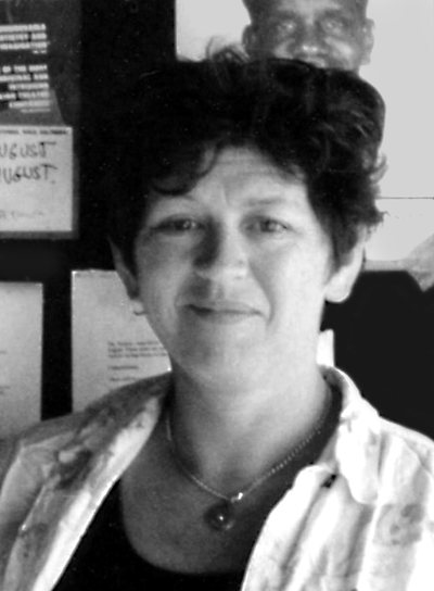 Heather Monk portrait Handspan Theatre fuzzy black and white photo of woman in front of a noticeboard