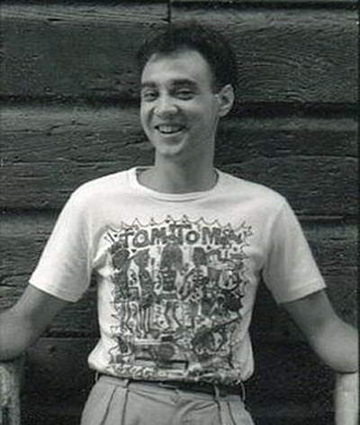 Winston Appleyard Handspan Theatre - a laughing young man leaning against a timber wall wearing a t-shirt saying Tom Tom