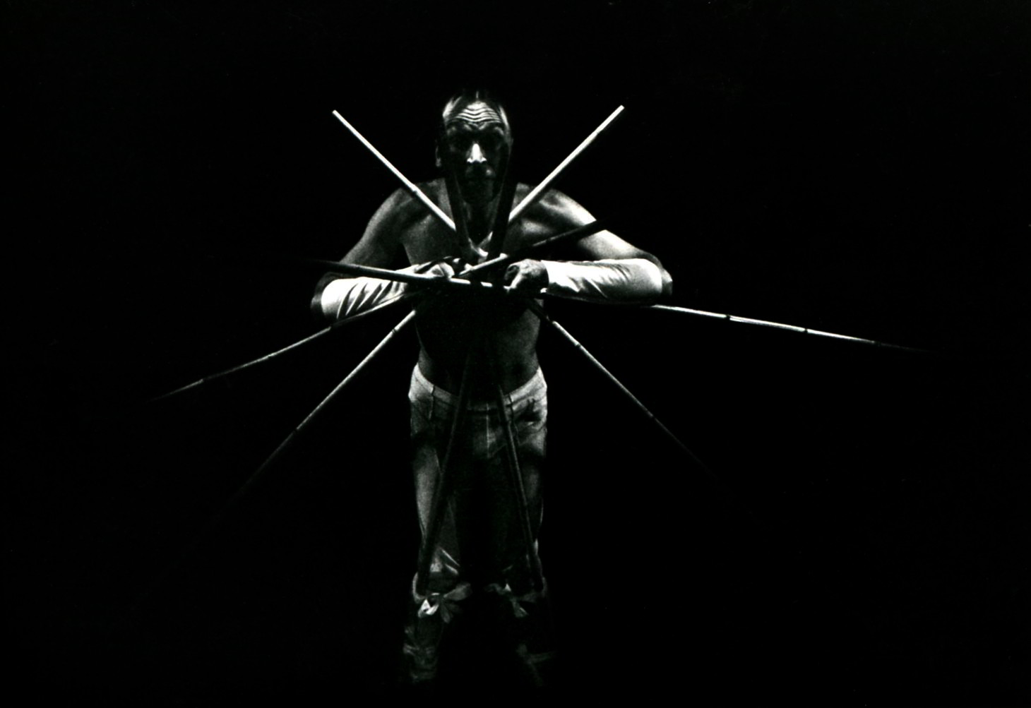 Peter J Wilson in SMALLS Handspan Theatre a man in light with cross bamboo sticks