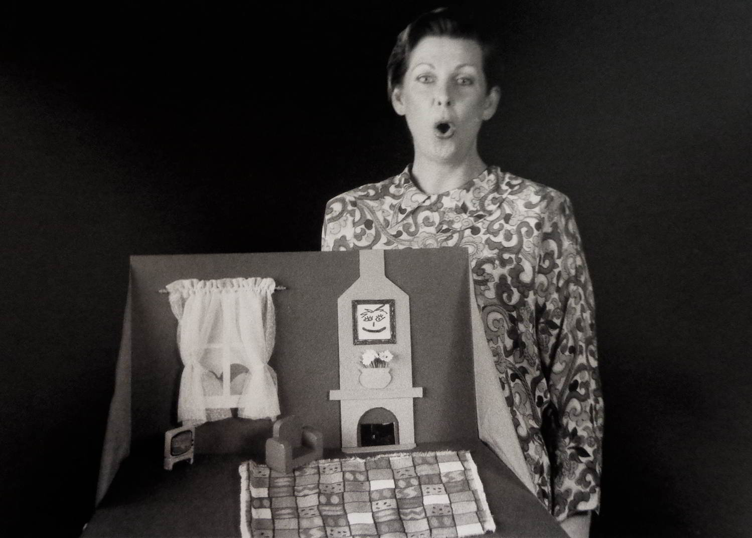 Handspan Theatre Women Alone Annie Wylie woman singing beside a small whimsical pop-up cardboard lounge room