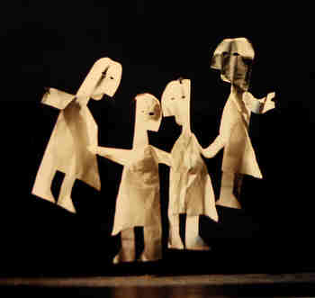 Four life-size paper dolls against a black background