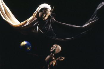 star has become floating child's head with long white draperies, wooden figure stands near globe of world, looking up