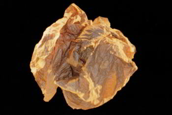 ball of brown paper floats above ball of white cloth